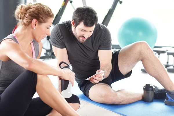 Man and woman taking a break after a workout — Stock Photo, Image