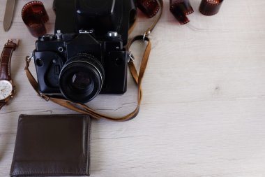 Fotoğrafçı, tasarımcı ya da hippi tarzı için alan iş. Bir film kamera, film, izle, m-cüzdan, bıçak üzerinde ahşap masa var.