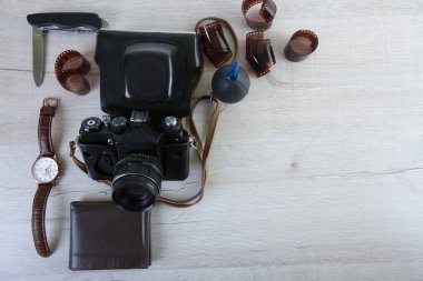 Fotoğrafçı, tasarımcı ya da hippi tarzı için alan iş. Bir film kamera, film, izle, m-cüzdan, bıçak üzerinde ahşap masa var.
