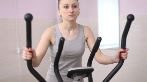 Treinamento de menina em um treinador elíptico — Vídeo de Stock