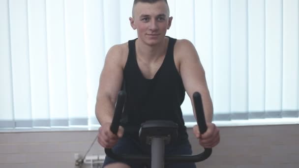 Hombre entrenando en una bicicleta estacionaria — Vídeo de stock