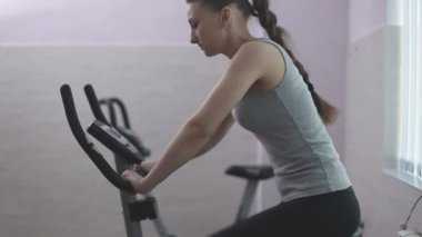 Kız üzerinde sabit bir bisiklet eğitim