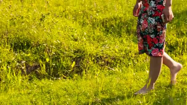 Barefoot girl walking on grass — Stock Video