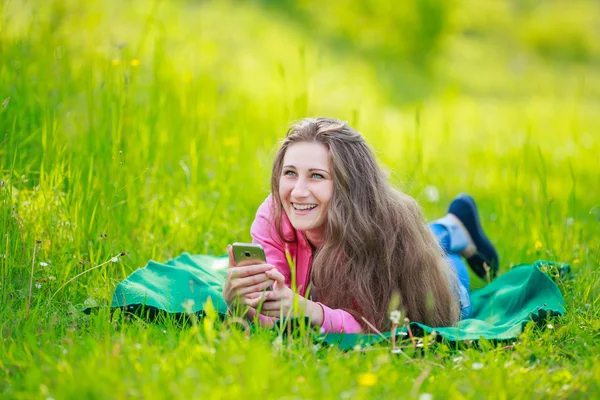 Telefon ile kadın yatıyor — Stok fotoğraf