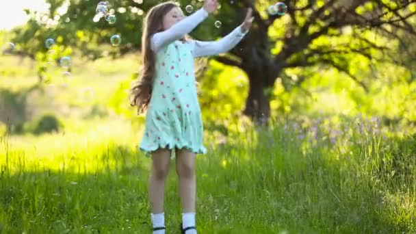 Девочка ловит пузыри — стоковое видео