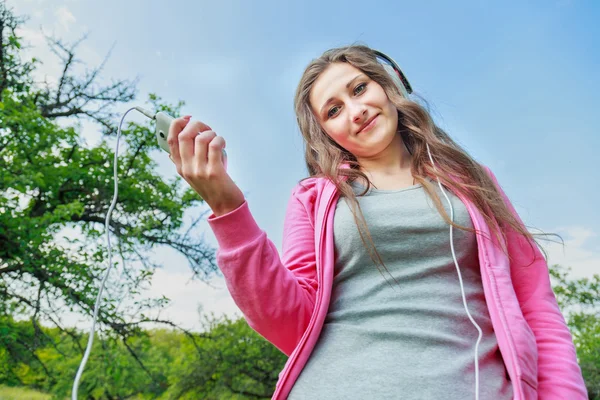 Ragazza con telefono e cuffie — Foto Stock