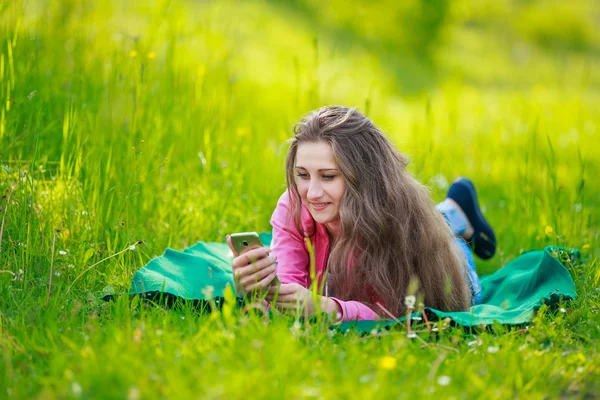 Telefon ile kadın yatıyor — Stok fotoğraf