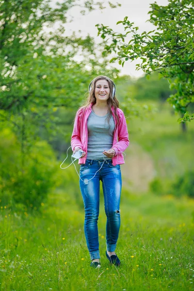 Menina com telefone e fones de ouvido — Fotografia de Stock