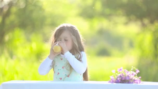 Meisje drinkt sinaasappelsap — Stockvideo