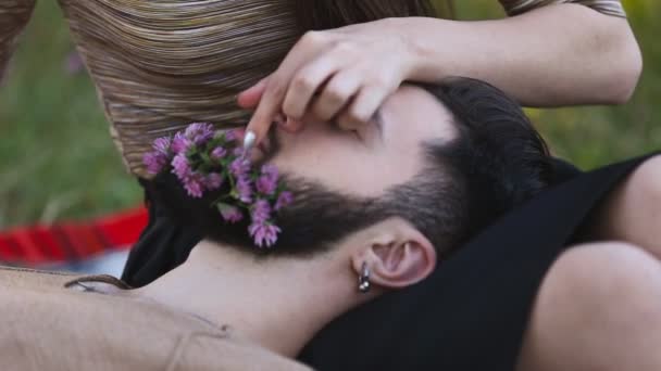 Flickan sätter en blomma i hans skägg mannen — Stockvideo