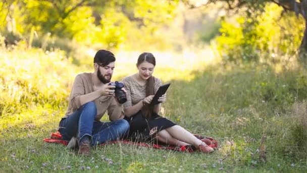 Jeune couple avec une tablette et appareil photo — Video