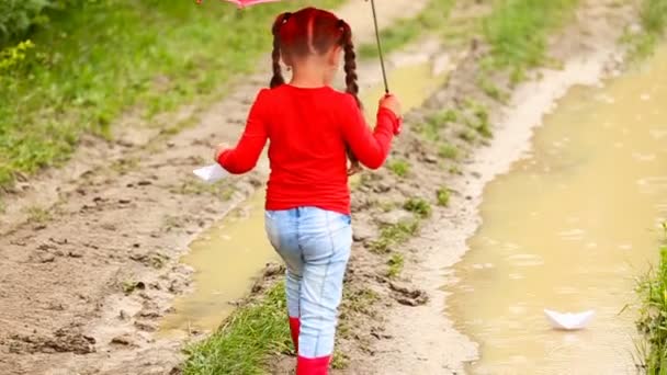 Girl launches a paper boat — Stock Video