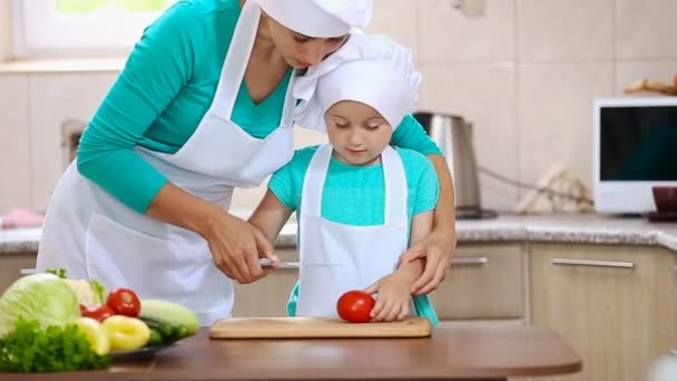 Mutter mit ihrer Tochter schneidet Tomate — Stockvideo