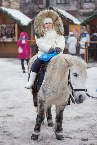 Kleines Mädchen reitet auf einem Pony — Stockfoto