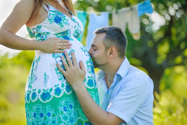 Happy expectant father kissing the belly of his pregnant wife Royalty Free Stock Photos