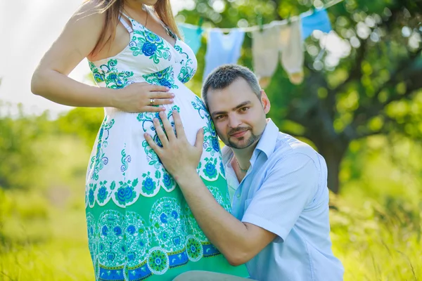 Šťastný otec poslouchá břicho těhotné manželky — Stock fotografie