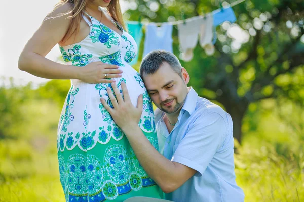 Šťastný otec poslouchá břicho těhotné manželky — Stock fotografie