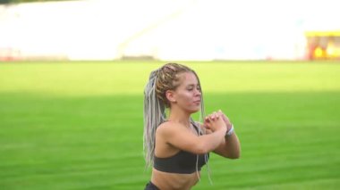 Kız stadyumda egzersiz yapıyor.