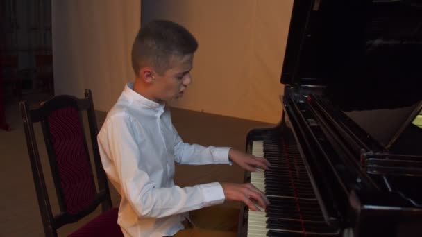 Мальчик играет на пианино — стоковое видео