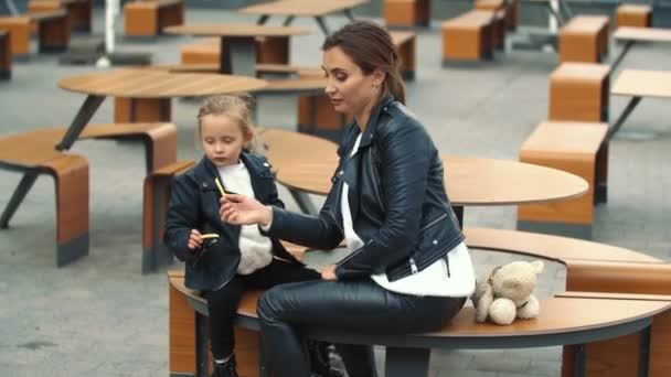 Mamá y su hija están sentadas a la mesa — Vídeo de stock