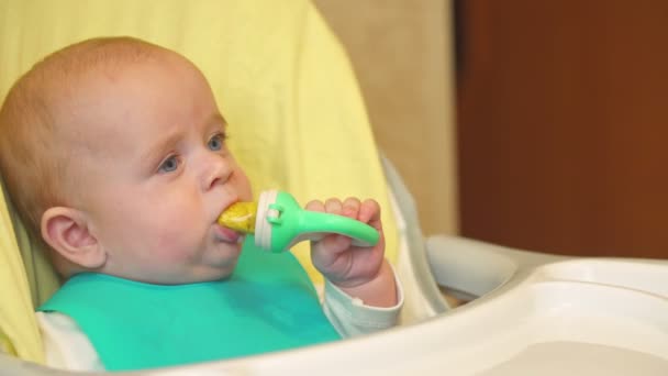 Le bébé s'assoit à la table et mange — Video