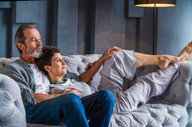 Kanepede oturan yaşlı çift.