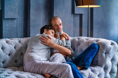 Çift kanepede otururken sarılıyor.