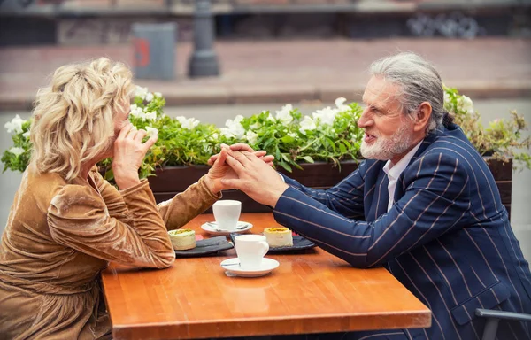 Elderly couple sitting at the table — Stock Photo, Image