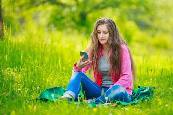 Flicka med en telefon i händerna — Stockfoto