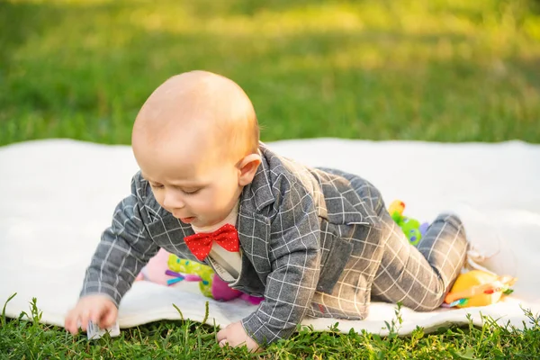 Niño sentado en una manta con juguetes — Foto de Stock
