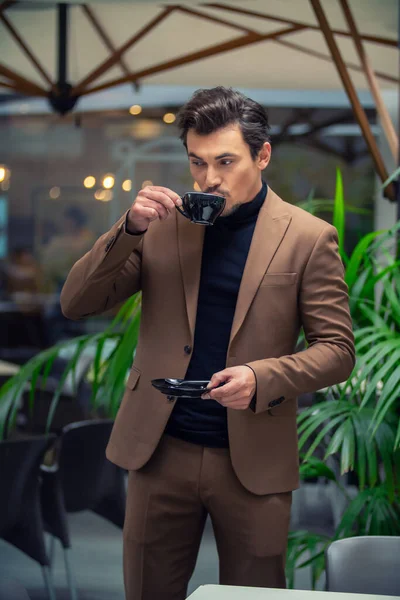 Un hombre en un traje de negocios bebiendo té — Foto de Stock