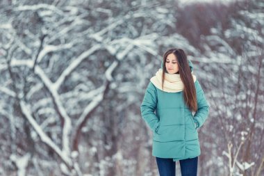 Karlı ağaçların arkasındaki kız.