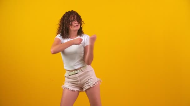 Meisje dansen op een gele achtergrond — Stockvideo