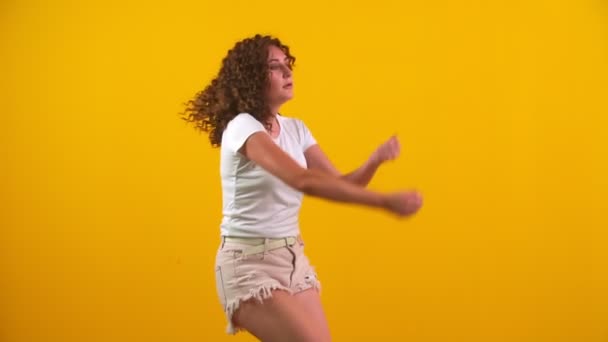 Meisje dansen op een gele achtergrond — Stockvideo