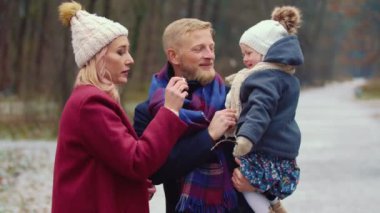 Genç bir aile parkta yürüyor.