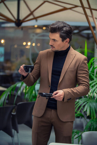 Человек в деловом костюме пьет чай