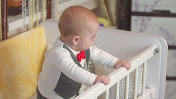 Little boy stands in the crib — Stock Video