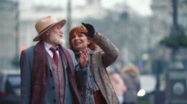 Yaşlı bir çift sokaklarda yürüyor.