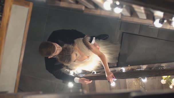 Νεαρό ζευγάρι στέκεται κοντά στις σκάλες — Αρχείο Βίντεο