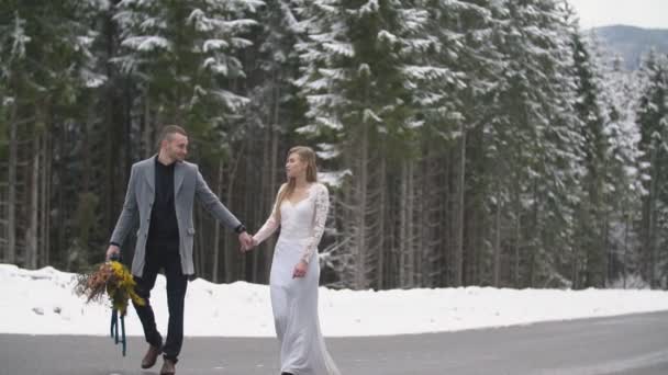 Пара гуляє в зимовому лісі — стокове відео