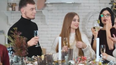 Şampanya kadehleri olan bir grup genç.