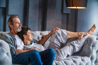 Kanepede oturan yaşlı çift.