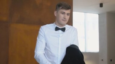 Adam takım elbisesini düzeltir.