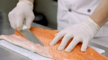 Bıçakla balık filetosu soyuyorlar.