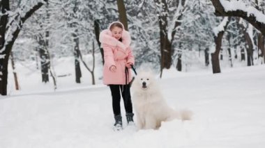 Samoyed köpeği olan bir çocuk.