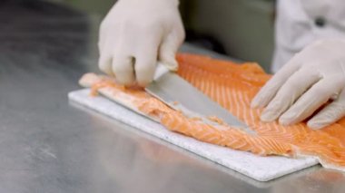 Bıçakla balık filetosu soyuyorlar.