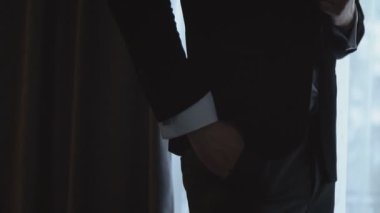 Adam takım elbisesini düzeltir.