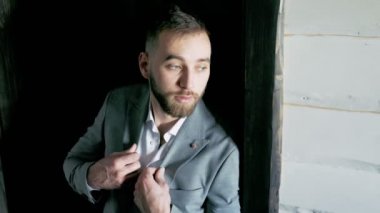 Takım elbiseli bir adam kapının yanında duruyor.