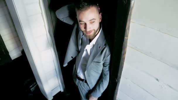 Egy öltönyös férfi áll az ajtó előtt. — Stock videók