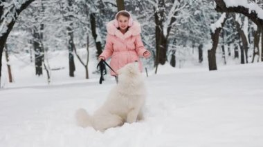Samoyed köpeği olan bir çocuk.